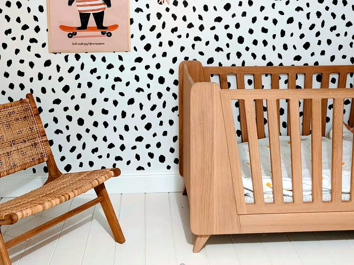 Chambre enfant avec papier peint à pois et lit en chêne