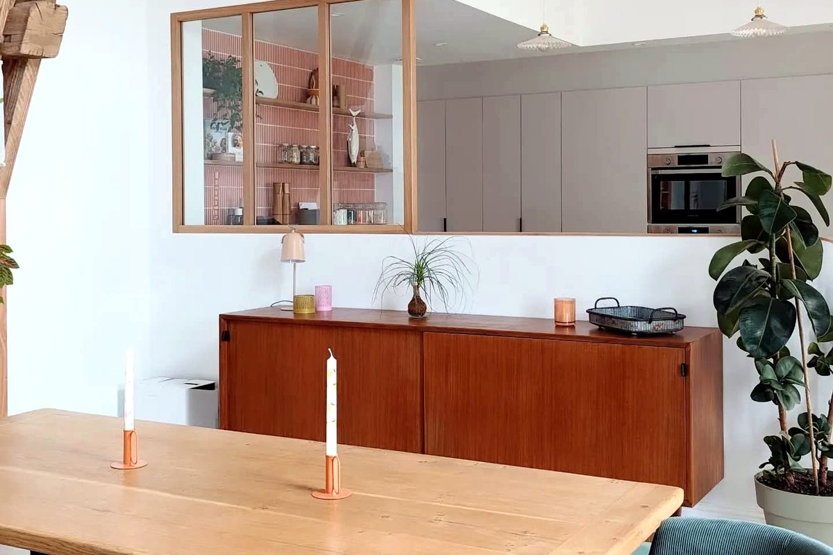 Pièce de vie ouverte avec table en chêne et verrière sur la cuisine